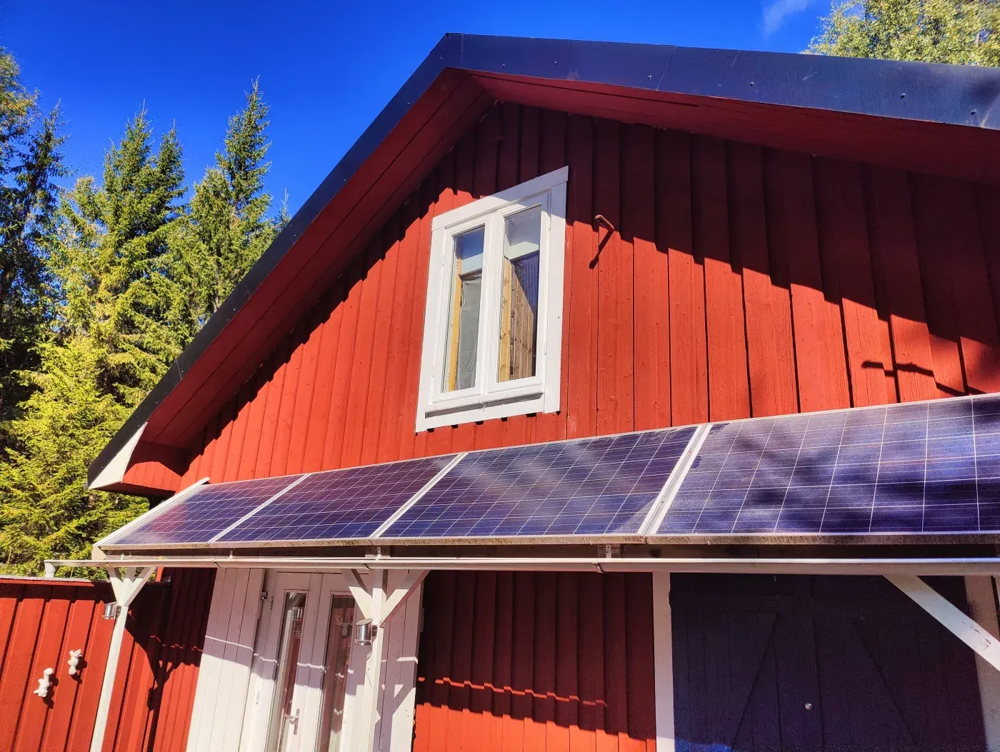 Painting work on a red timber facade in Sweden