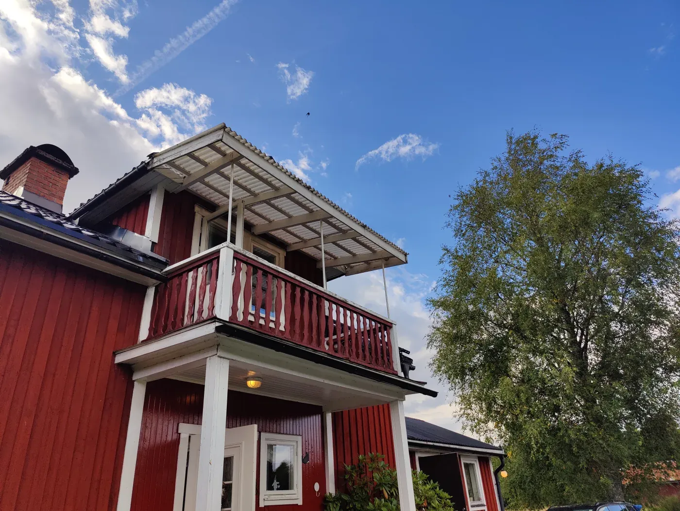 Balcony and canopy of a red timber house in Sweden