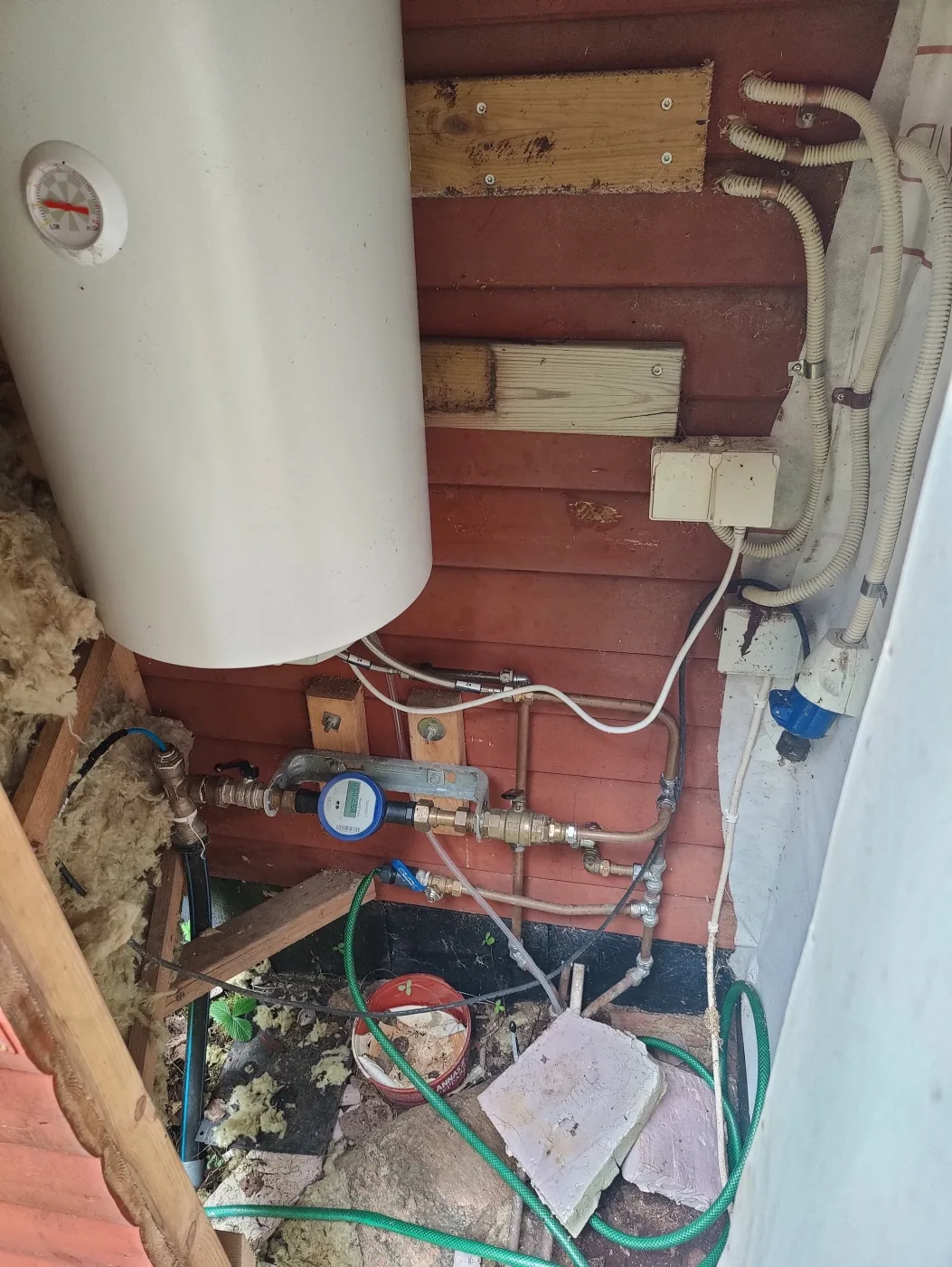 Water heater, water meter and visible pipes in a Swedish property